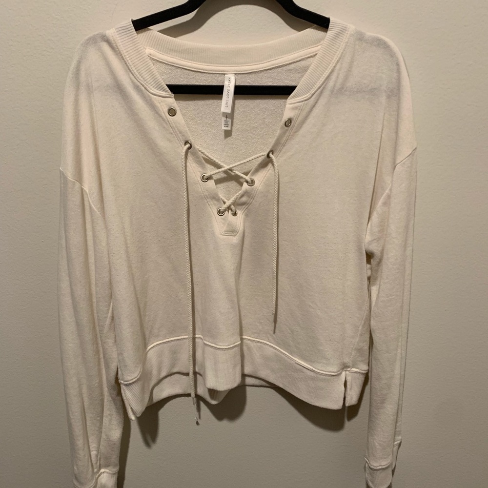 Cream colored crop top with lace-up neckline